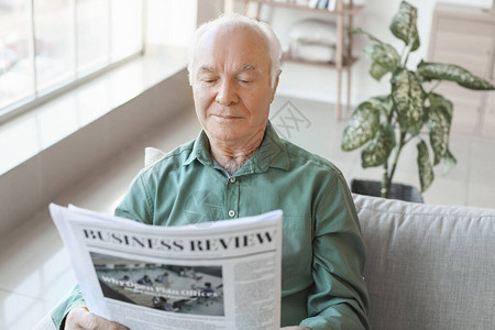 老年男子在家阅读报背景图片
