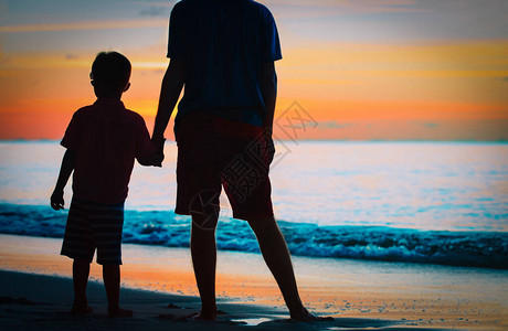 父亲和儿子在日落的海中牵手父亲和图片