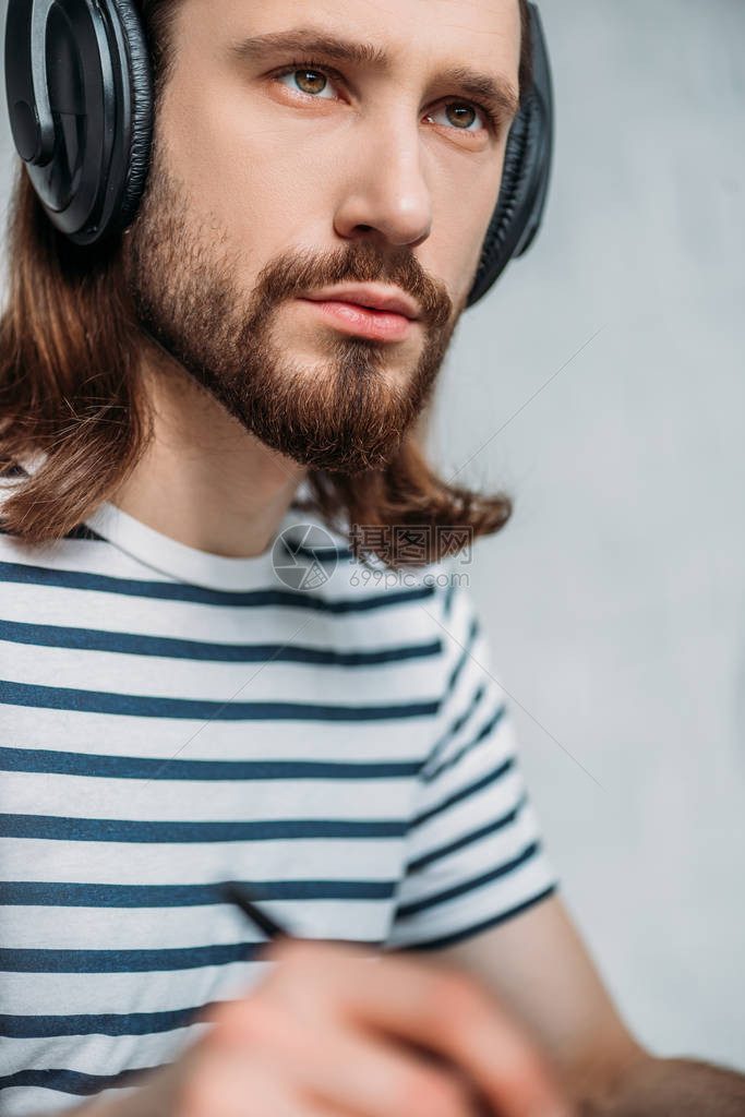 用耳机监听音乐的英俊长胡子图片