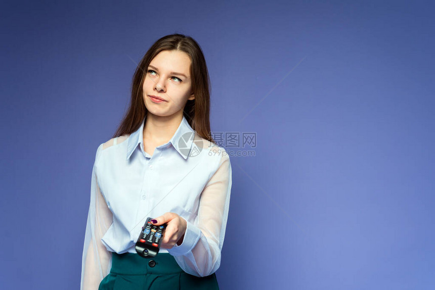这位穿蓝色衬衫的女士对电视上有关冠状的新闻感到失望和厌倦女孩切换频道并因电影而生气可爱的女孩在淡紫色图片