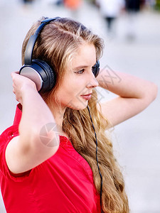 学生听耳机女孩在考试后聆听音乐该是在街头城市放松了散步有图片