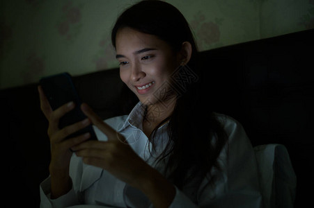特写亚洲女睡觉和使用智能手机进行社交网络或视频电话会议图片