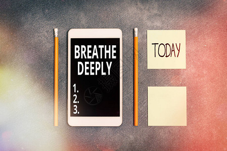 手写文字书写深呼吸将大量空气吸入肺部的概念照片完全吸气呼纸附件与数字智能手机排列背景图片