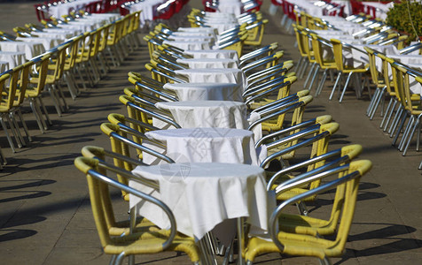 室外餐厅的许多椅子和桌子图片