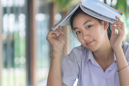 穿着制服的年轻青女大学生坐在咖啡厅图片