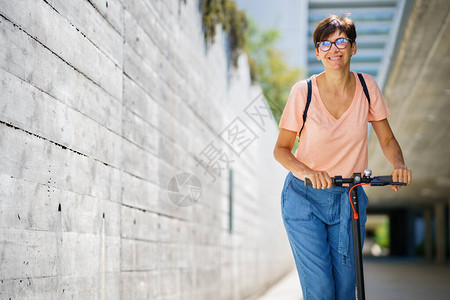 中年女乘坐电动摩托车在图片