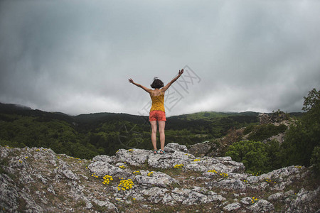 一个女孩站在山顶上一个女人站在悬崖图片