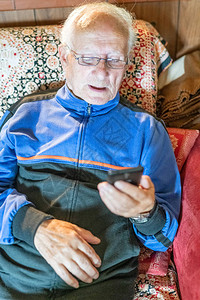戴眼镜的老人在家看手机图片