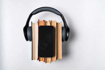 白色背景的书籍耳机和智能手机图片