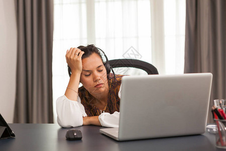 在家上班时带耳机的睡着妇女图片