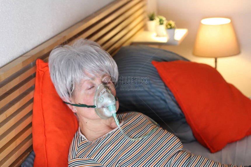 身戴氧气面罩的成年白头发妇女图片