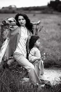 母亲与女儿在田野森林附近的一个图片