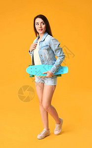 在彩色背景上带滑板的酷年轻女人背景图片