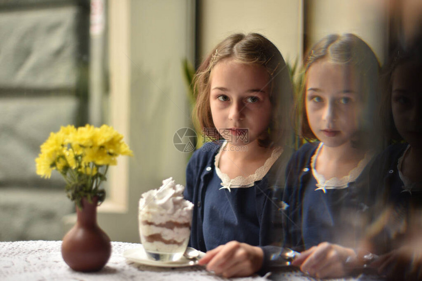 小女孩在咖啡馆里喝热巧克力女学生在咖啡馆里喝可女孩在咖啡馆下课后喝可图片
