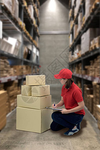 女工作人员和包裹箱检查库存或准备发货和模糊仓库背景图片