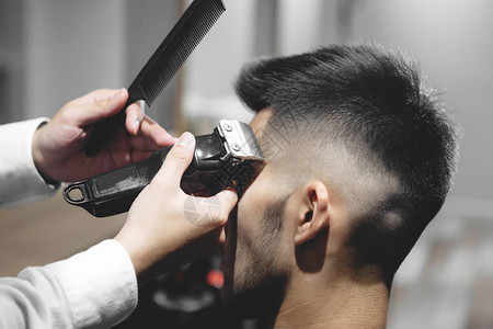 年轻美发师剪头发在美容院梳理男人图片