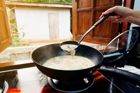 女人的手在用锅子煮饭图片