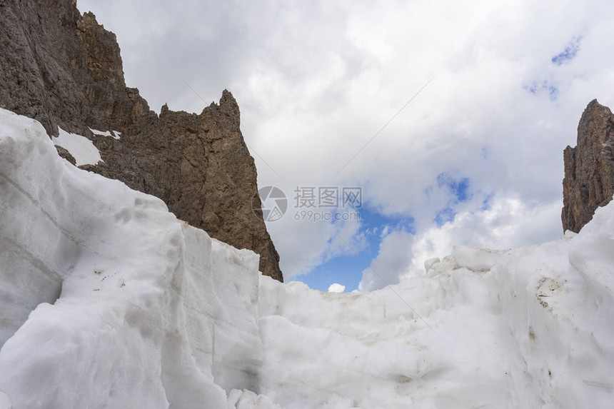 云层背景下的雪和岩石在萨索隆戈山图片