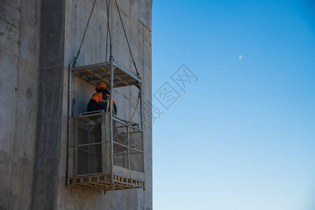 建设跨河公路桥交汇处建筑工地上的建筑工人和建筑设备对蓝天图片