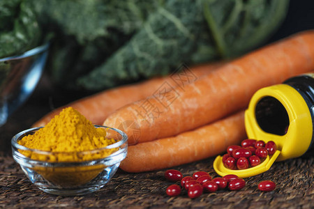 胡萝卜素补充丸剂和新鲜蔬菜中胡萝卜素的天然来源抗氧化补充剂和胡萝卜背景