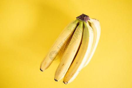 黄色背景上的甜香蕉束顶视图图片