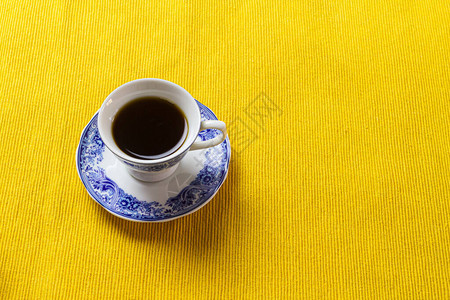 黄色餐垫上的陶瓷咖啡杯图片