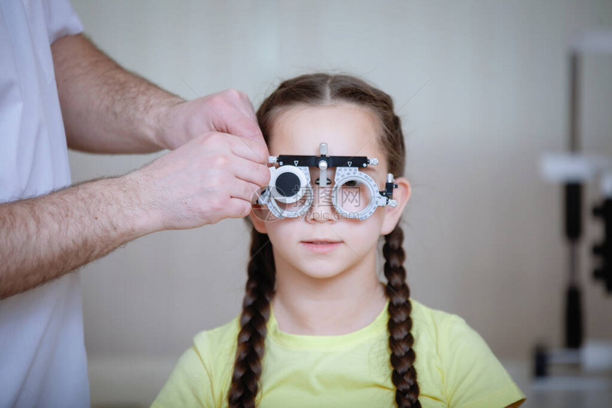 眼部检查由Ophthalmalogist测试眼镜框为身穿黄色短袖圆领汗图片