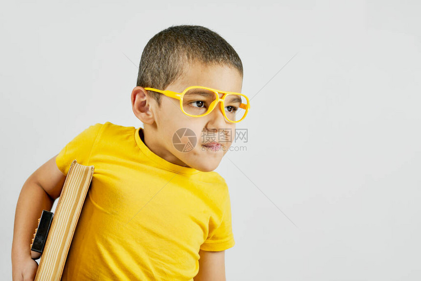 黄色的滑稽男孩的肖像带着一本大图片