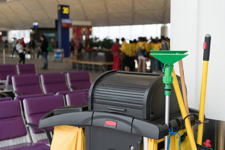 拖把桶和一套清洁设备在国际机场与团体旅客在航站楼门前作为背景背景图片