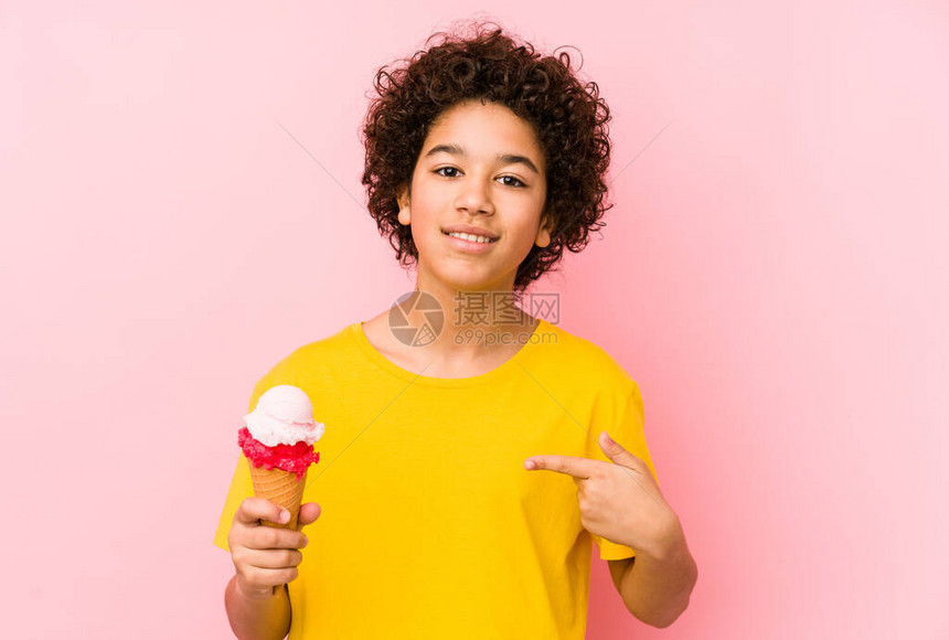 小男孩拿着一个冰淇淋孤立的人用手指着一件衬衫的复制空图片