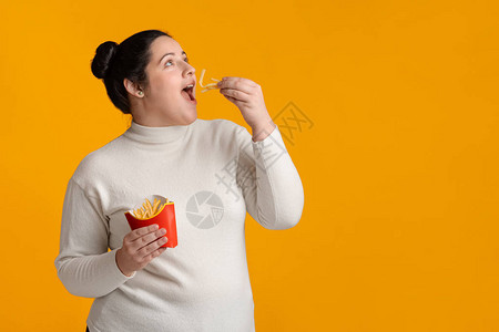 饥饿超重女孩食用法式美味薯条图片