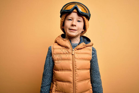 穿雪眼镜和冬衣的幼小caucasian孩子图片