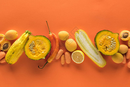 橙色背景下黄色水果和蔬菜的顶视图图片