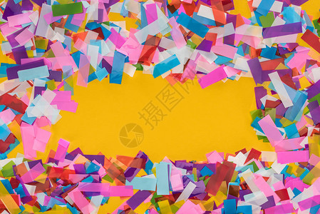 黄色背景面上带有复制空间的多色彩confetti图片