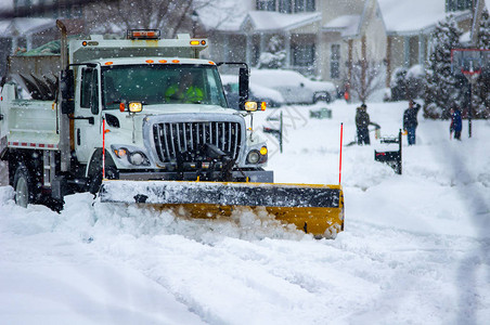 在严冬暴风雨过后清理道路的城市服务排雪车前雪花扫雪图片