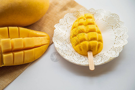 芒果冰淇淋棒在白盘上芒果在白桌背景上图片