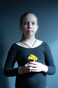 画室里一个带着黄色花朵的小女孩的画像背景图片