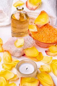 含橙色花粉浴盐透明玻璃瓶和香水基本油白毛巾玫瑰花瓣和图片