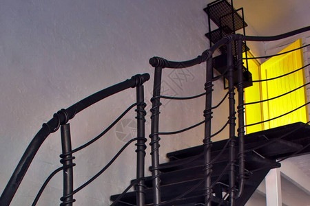通往黄色出口门的黑色楼梯图片