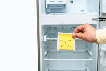 白色孤立的空开式冰箱旁带着悲伤笑图片