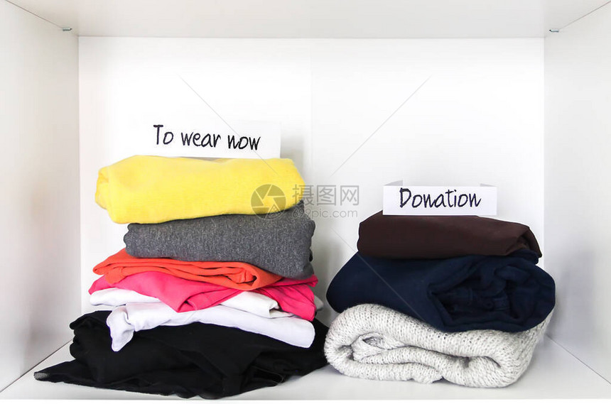 穿戴和捐赠衣物在衣柜中分类白色架子背景上的不图片