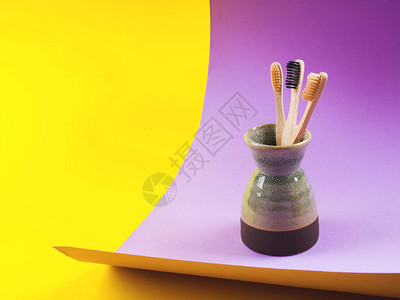 黄纸和紫纸背景的竹布牙刷图片