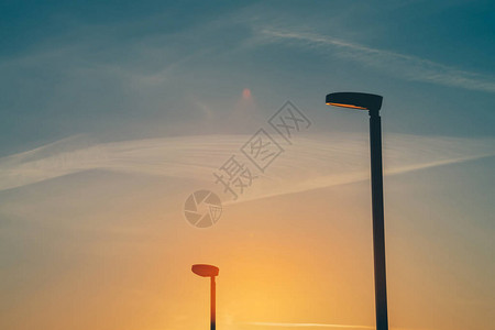 日落特写时防止光污染的特殊日出天空梯度温暖的自然背景黎明与路灯杆的剪影极简主义黎明背景图片