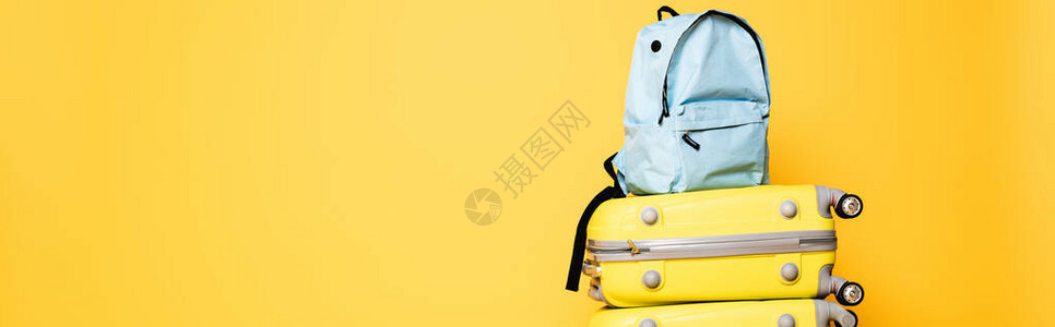 旅行袋上的蓝色背包在黄色全背景图片