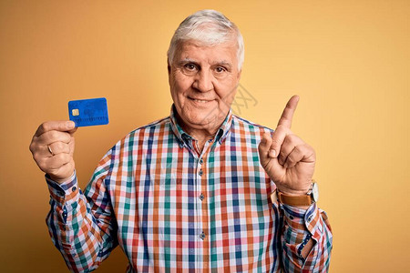 年长英俊的老顾客拿着信用卡为付款提供资金图片