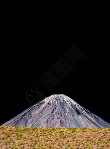 黑色天空下有金字塔形的火山图片