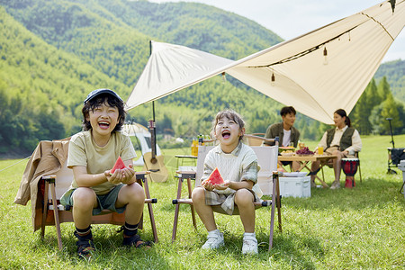 夏日亲子儿童户外露营开心吃西瓜背景