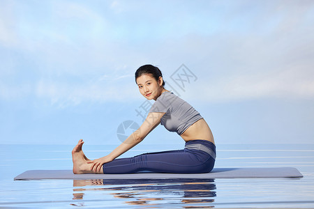 女性做禅意瑜伽的水面倒影图片