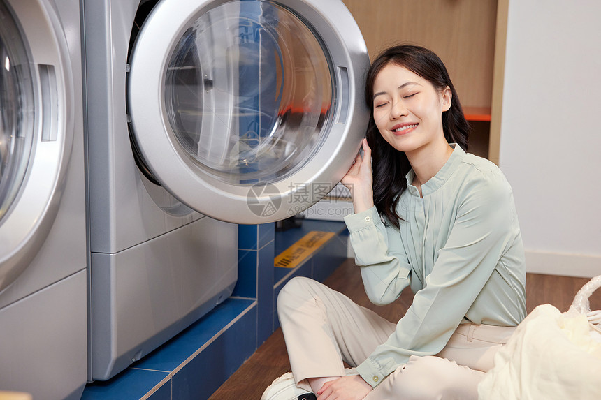 用洗衣机洗衣服的女性形象图片