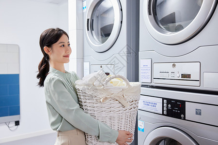 洗衣机房洗衣服的职场女性图片